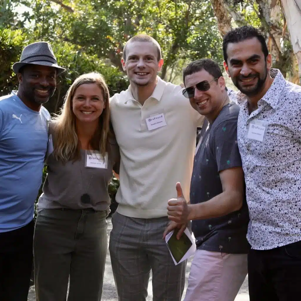 Russell Lehmann in the middle of a group of people smiling at the camera