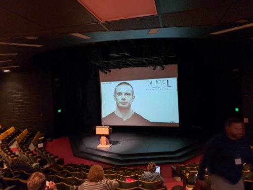 Russell Lehmann on a large projector screen 