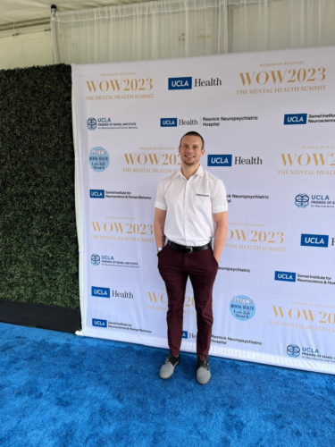 Russell Lehmann standing in front of WOW2023 backdrop