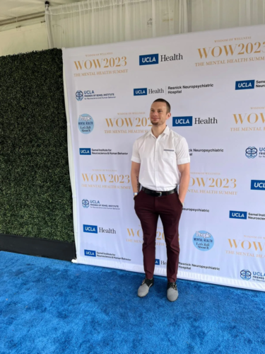 Russell Lehmann standing in front of WOW2023 backdrop