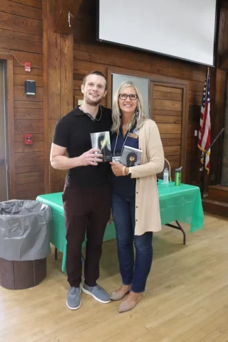 Russell-standing-with-one-person-holding-his-book